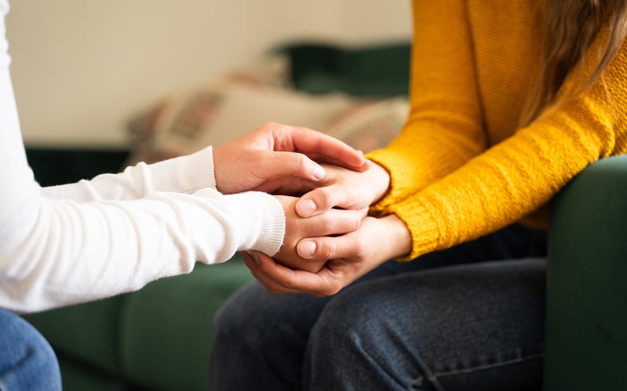 One woman holding another woman hand during a heartfelt conversa