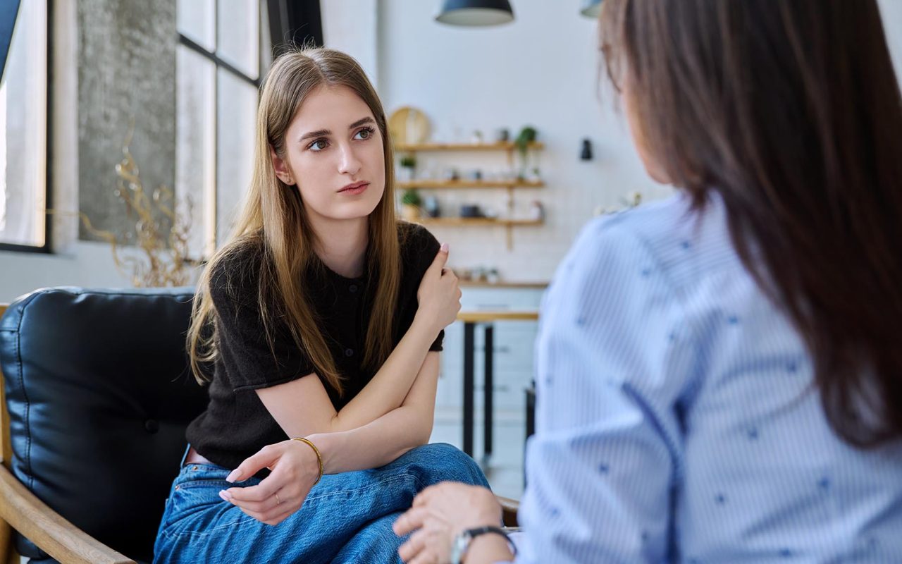 Young woman talking to social worker, home meeting, home visit of psychological counselor, survey consultation. Social services, psychology psychotherapy help treatment support, mental health, youth